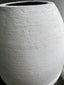 Closeup of Sak' Tall GFRC Outdoor Planter, a tall, elegant vessel finished in a stunning white stucco texture.